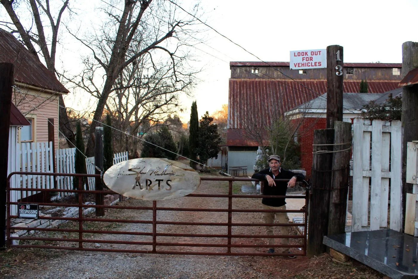 Stan Mullins at the gate of his Pulaski Street studio